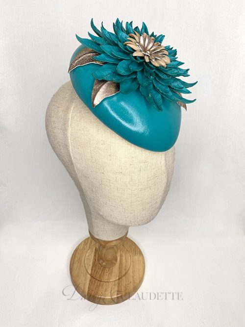 Deep teal leather oval beret with a very large statement leather flower of the same colour, with contrasting centre of nude and vintage gold petals and a gold pearl.