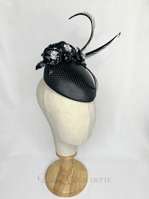 Black perforated leather percher on a luxurious cream felt base trimmed with black leather flowers and three black curled feathers