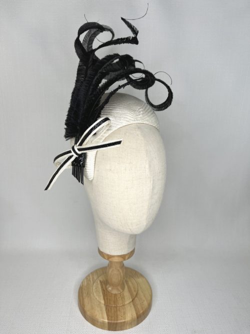 Sinamay straw bandeau fascinator with a large feather flower and two curled feather quills.