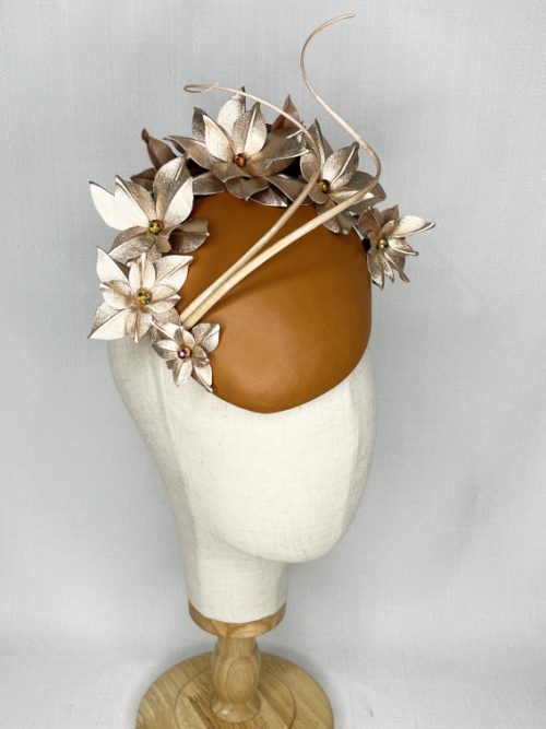 Tan leather beret headpiece with metallic flowers and curled feather quills